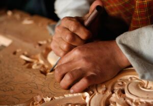 Close-up handen houtsnijwerk tempel Bhutan