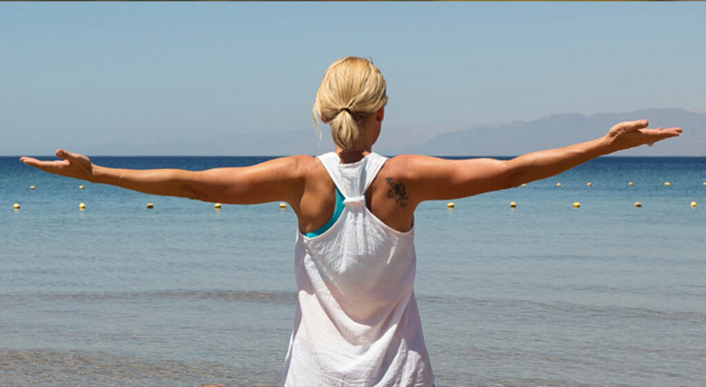 Letting go image arms wide at the beach