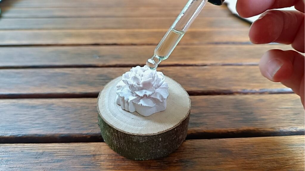 Handgemaakte aromasteen op houten schijfje met pipet en etherische olie
